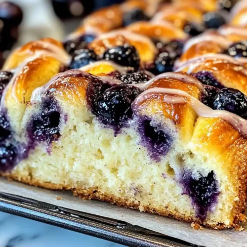 Moist and tangy Lemon Blueberry Swirl Bread with a golden crust and visible blueberry swirl patterns.